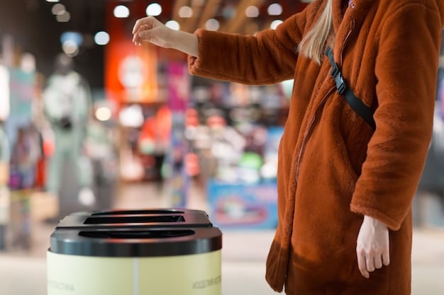 A Shein recycling bin in a brightly lit shopping mall. People are shown dropping clothing items into the bin. The bin has the Shein logo prominently displayed.