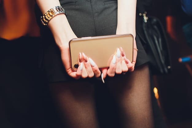 A close-up of a stylish woman's hand holding a modern clutch, with subtle jewelry accents. The background is blurred and is a trendy bar.