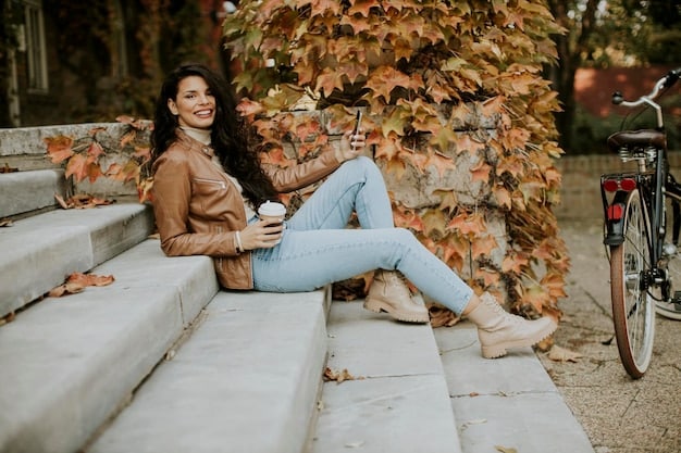A woman sitting on a park bench wearing mom jeans, a tucked-in graphic tee, and white sneakers, casually enjoying a coffee. The scene is natural and the lighting is soft.