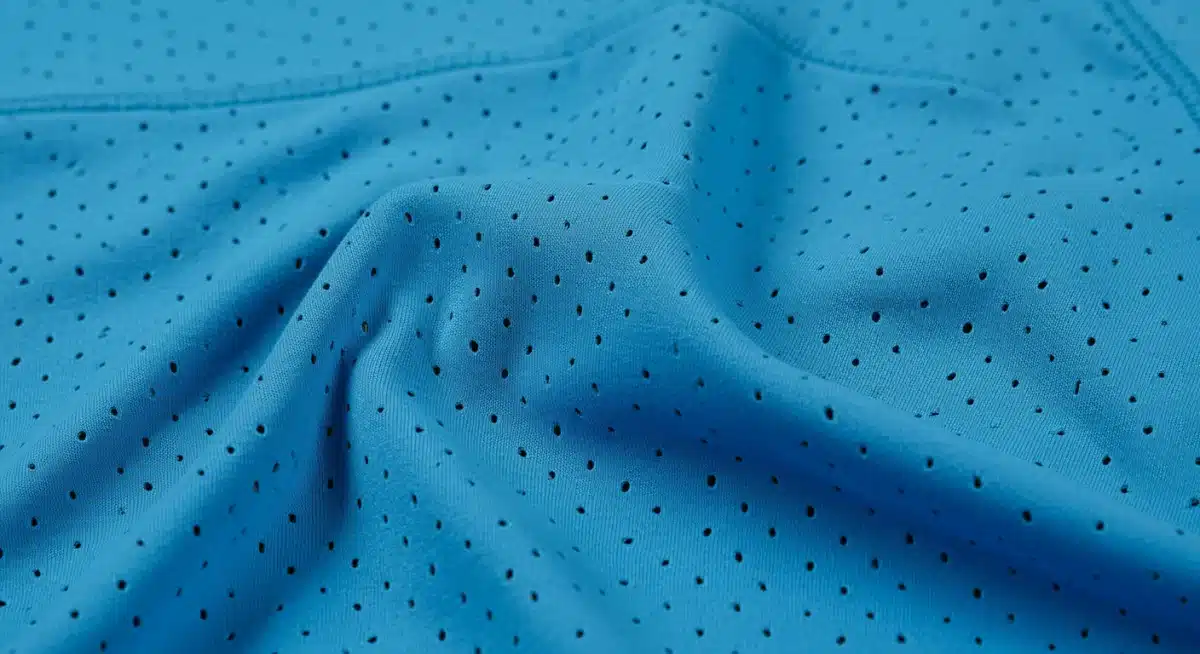 Gros plan sur le tissu respirant et extensible d'un vêtement de sport SHEIN, mettant en évidence sa texture et sa couleur bleue vibrante.