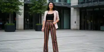 Jeune femme élégante portant des vêtements SHEIN à rayures verticales et un pantalon taille haute, souriante et confiante, dans un décor urbain moderne.